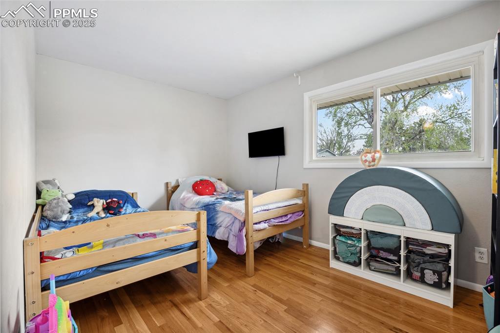 Image 17 of 39: Bedroom with wood finished floors and baseboards