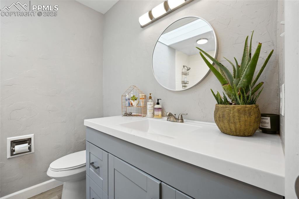 Image 21 of 39: Bathroom featuring wood finished floors, toilet, and vanity