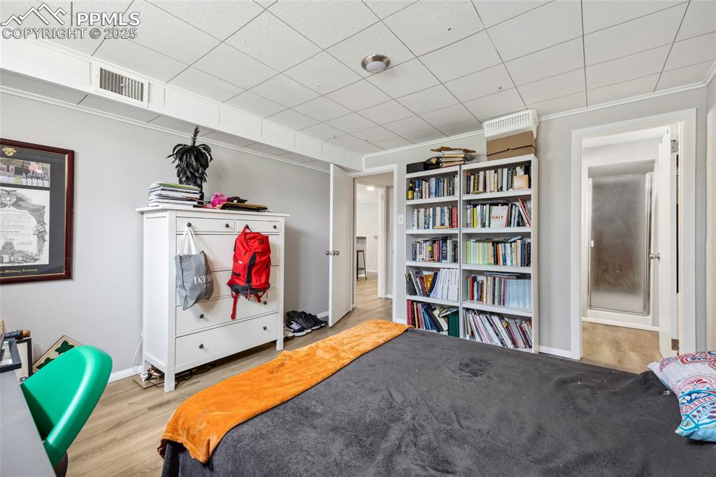 Image 27 of 39: Bedroom featuring wood finished floors, visible vents, and crown molding