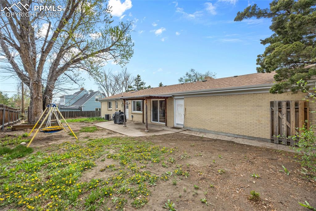 Image 32 of 39: Back of property with a patio area, brick siding, and a fenced backyard