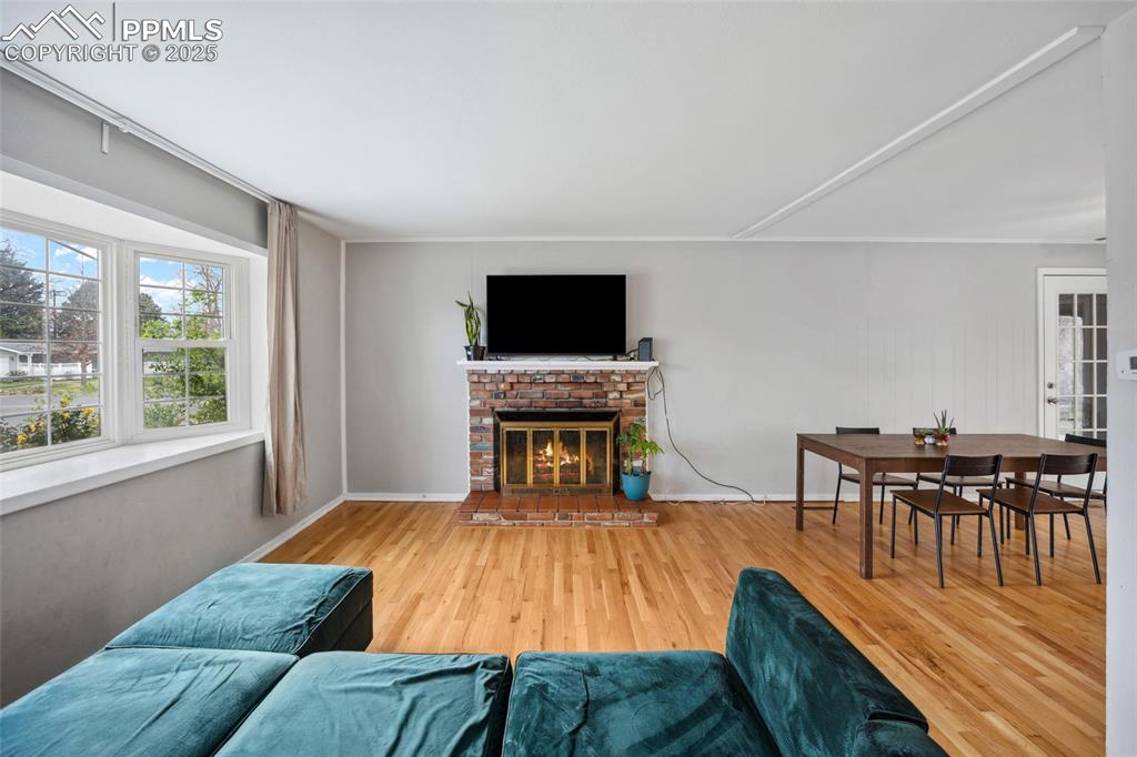 Image 5 of 39: Living room featuring wood finished floors and a fireplace