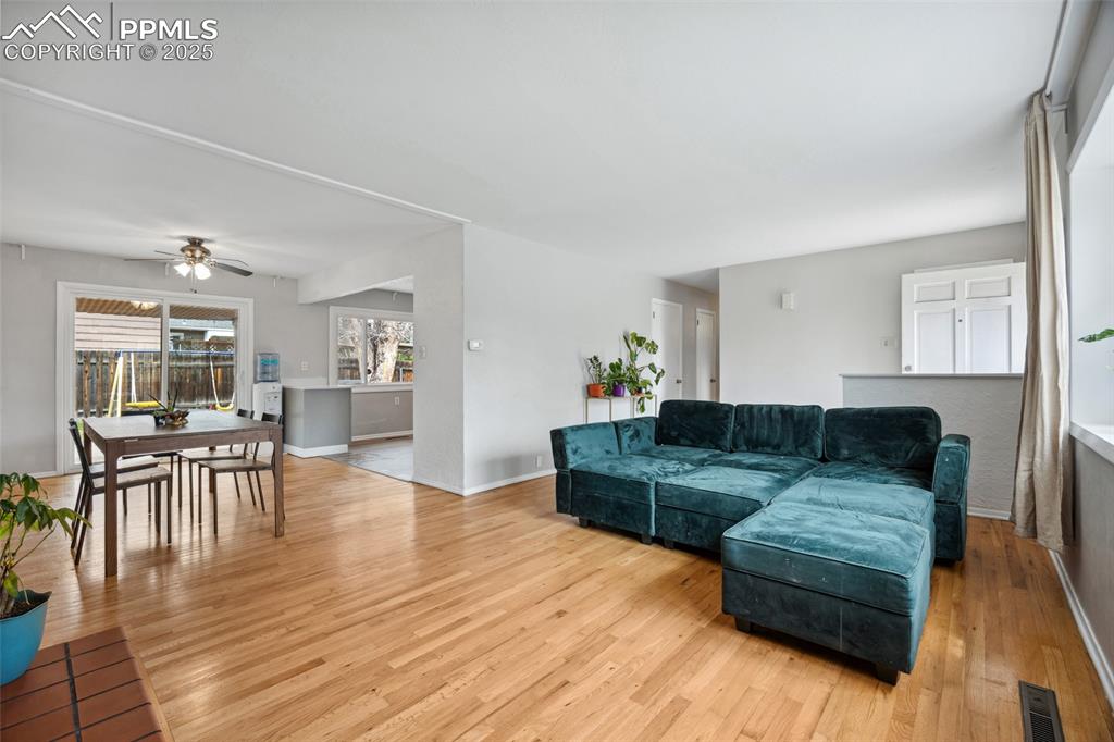 Image 6 of 39: Living area featuring visible vents, ceiling fan, baseboards, and light woo