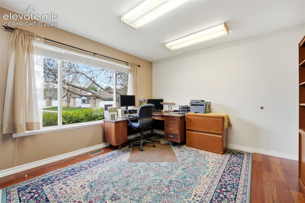Image 19 of 47: Second bedroom on main level with walk in closet, currently used as an off