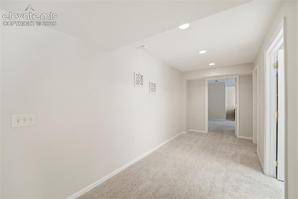 Image 33 of 47: Generous hallway connecting the expansive lower-level living spaces
