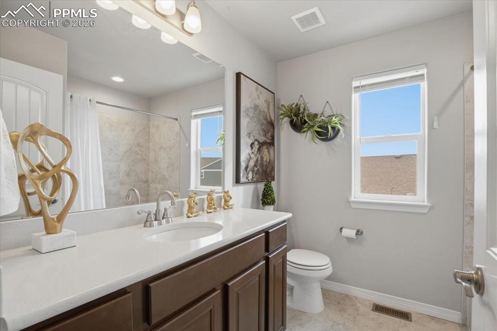 Image 15 of 40: Bathroom with vanity and a shower with shower curtain