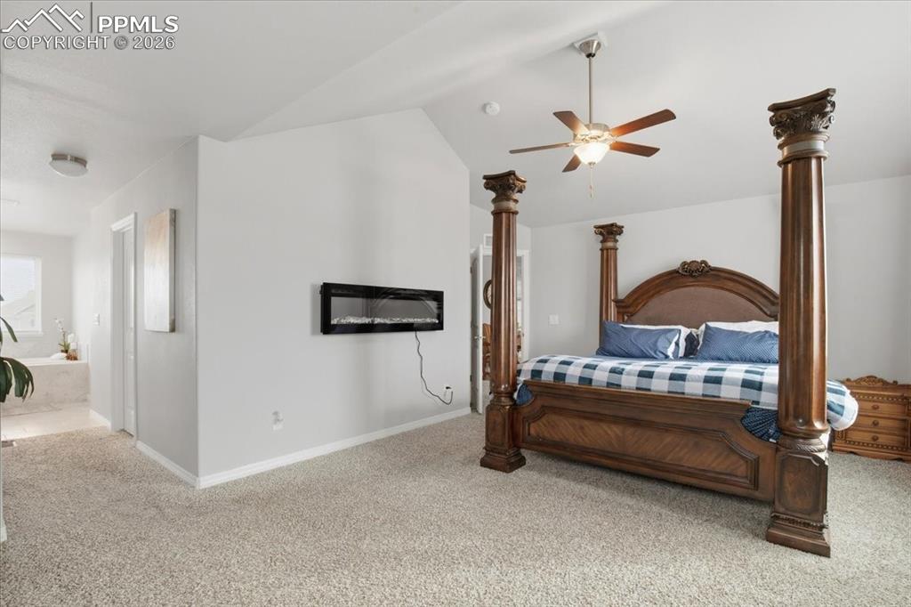 Image 23 of 40: Bedroom featuring carpet floors, ceiling fan, vaulted ceiling, and ensuite 