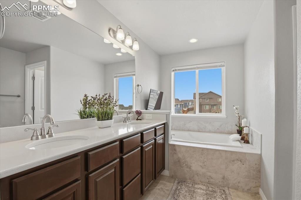 Image 24 of 40: Full bathroom featuring double vanity and a garden tub