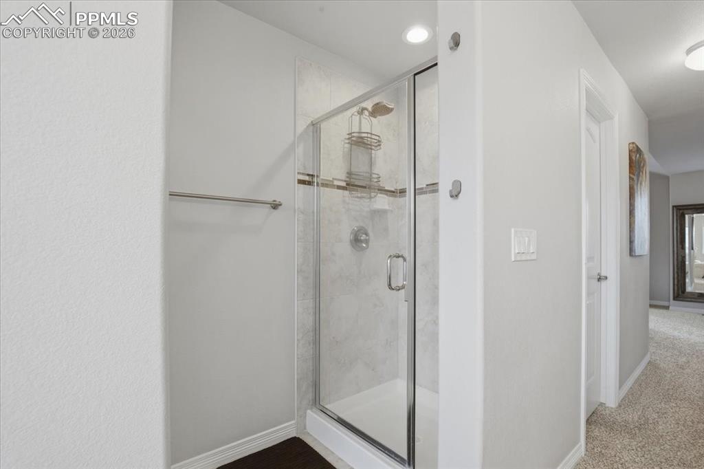 Image 26 of 40: Bathroom with a stall shower, carpet, and recessed lighting