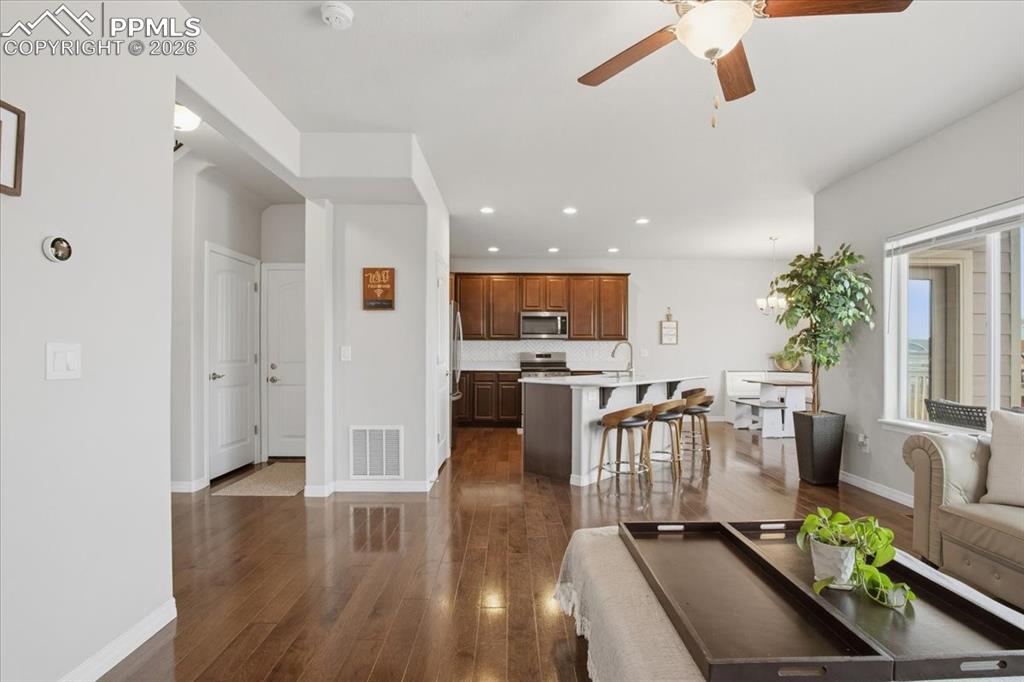 Image 8 of 40: Living room with ceiling fan, dark wood finished floors, recessed lighting,