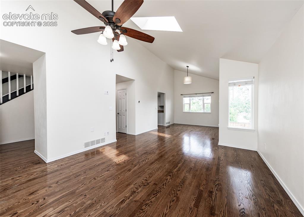 Image 10 of 41: Spacious interior featuring wood-finish flooring, vaulted ceilings, and a l