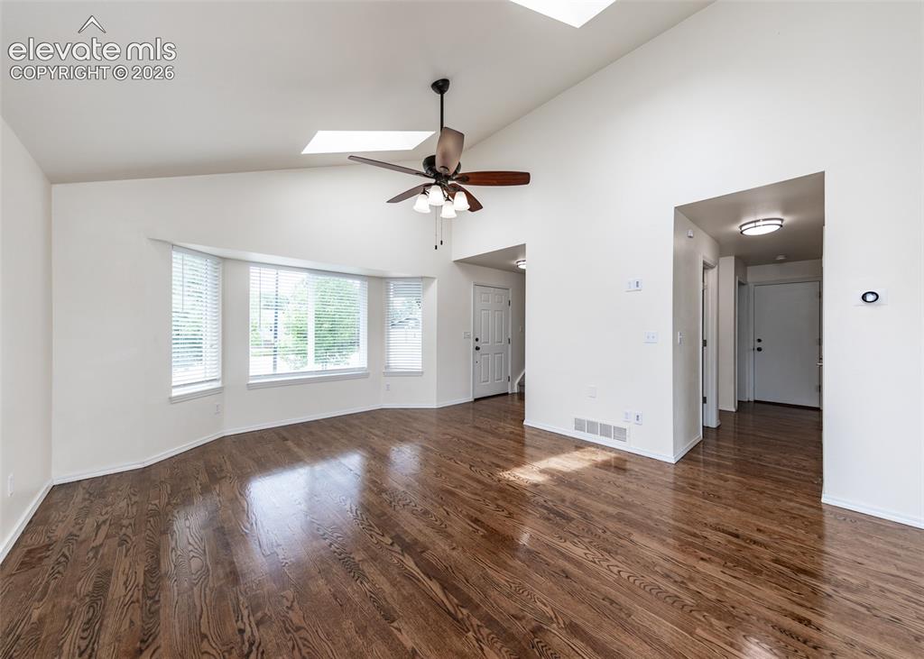 Image 12 of 41: Spacious living area featuring high vaulted ceilings, multiple skylights, a