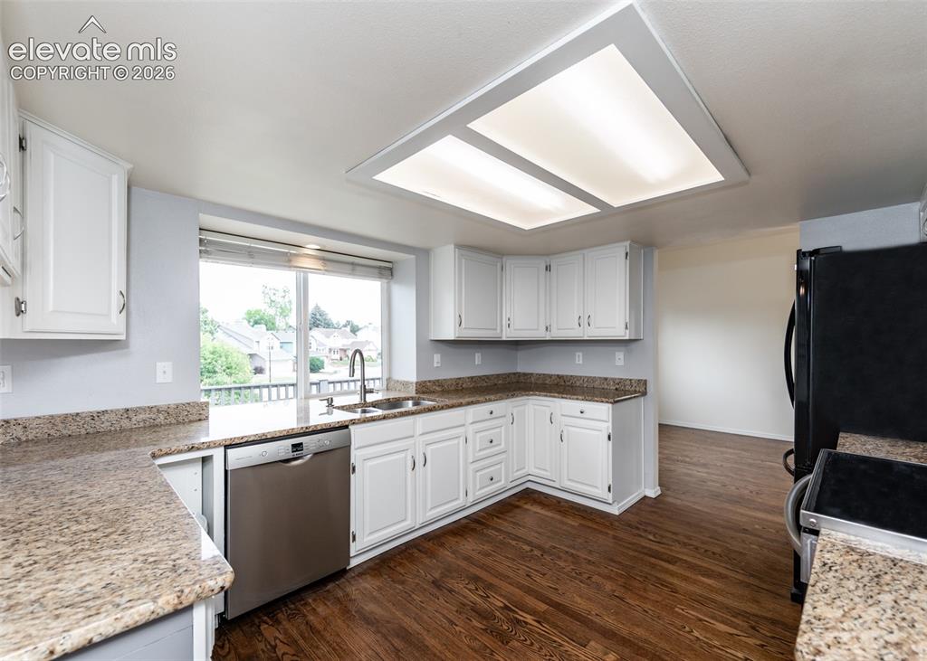 Image 14 of 41: Kitchen featuring white cabinetry, granite countertops, stainless steel sin