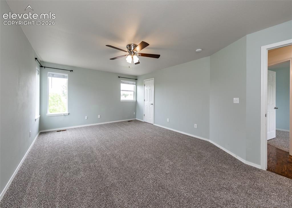 Image 23 of 41: Spacious room featuring gray textured carpeting, light blue walls, and whit