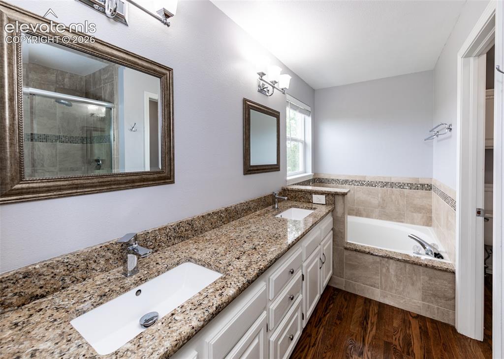 Image 27 of 41: Dual vanity featuring granite countertops with undermount sinks and chrome 