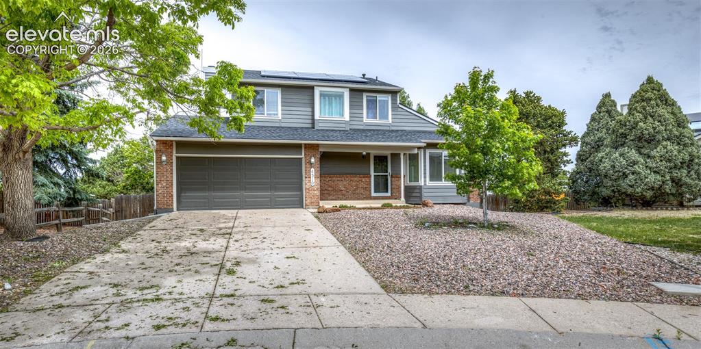 Image 3 of 41: Two-story residence featuring a two-car garage, partial brick facade, and g