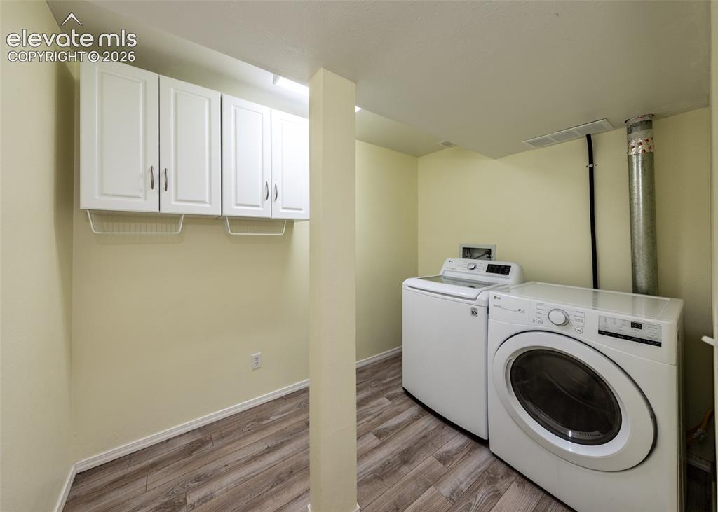 Image 31 of 41: Dedicated laundry area featuring wood-finish flooring, white wall-mounted c