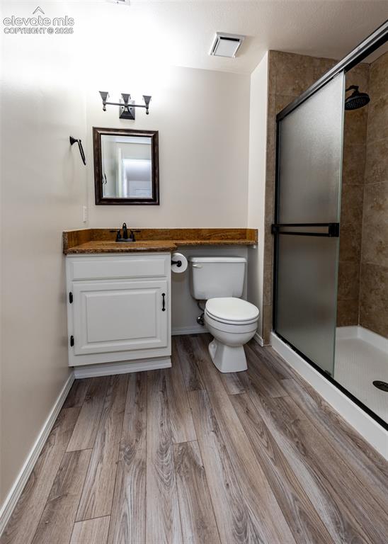 Image 33 of 41: Bathroom featuring wood-finish flooring, a white vanity with granite-style 