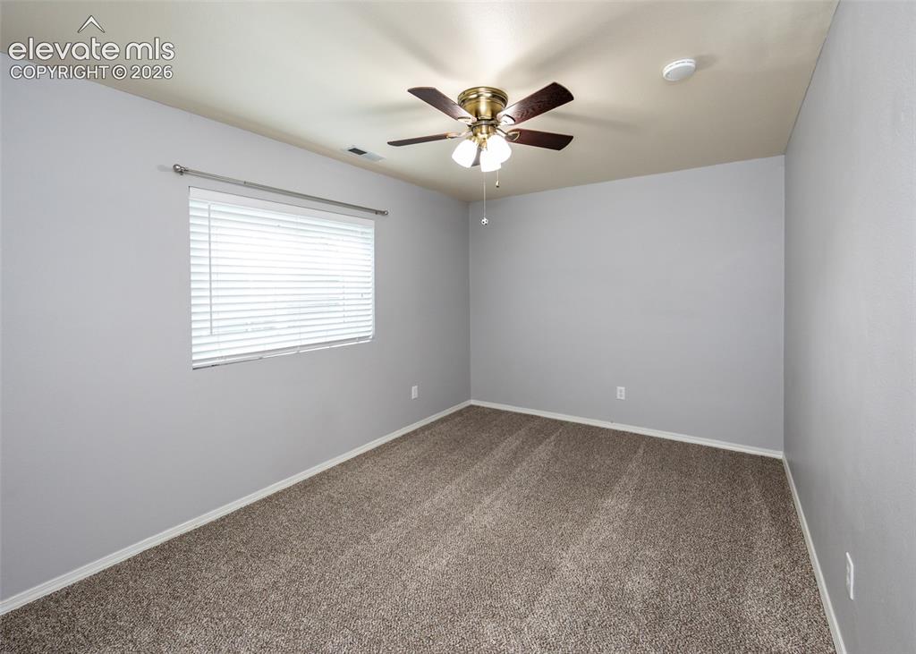 Image 34 of 41: Spacious room featuring neutral carpeting, light gray wall paint, and a cei