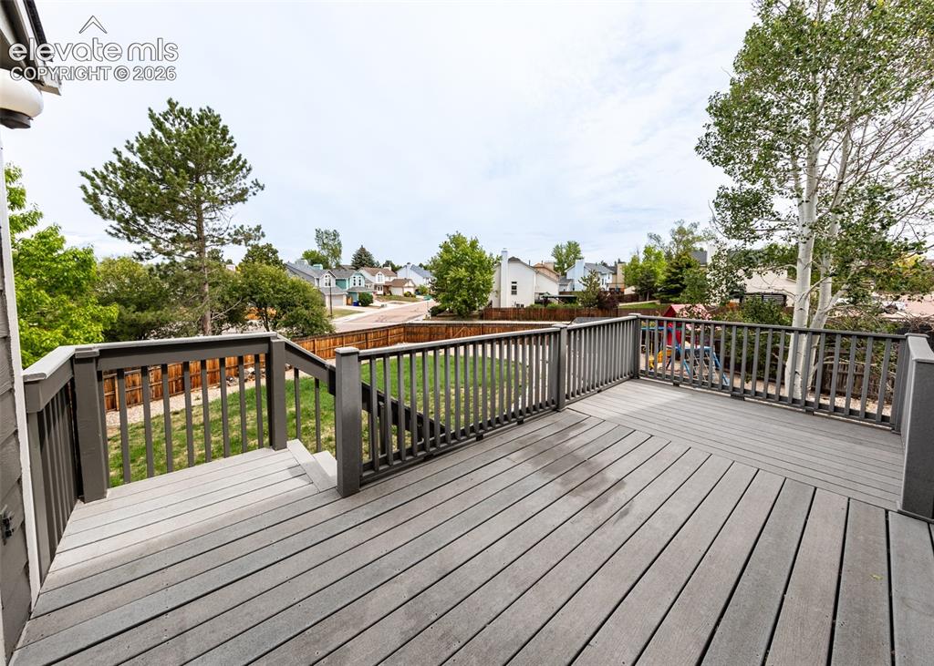 Image 35 of 41: Spacious outdoor deck featuring composite decking and railing, a privacy fe