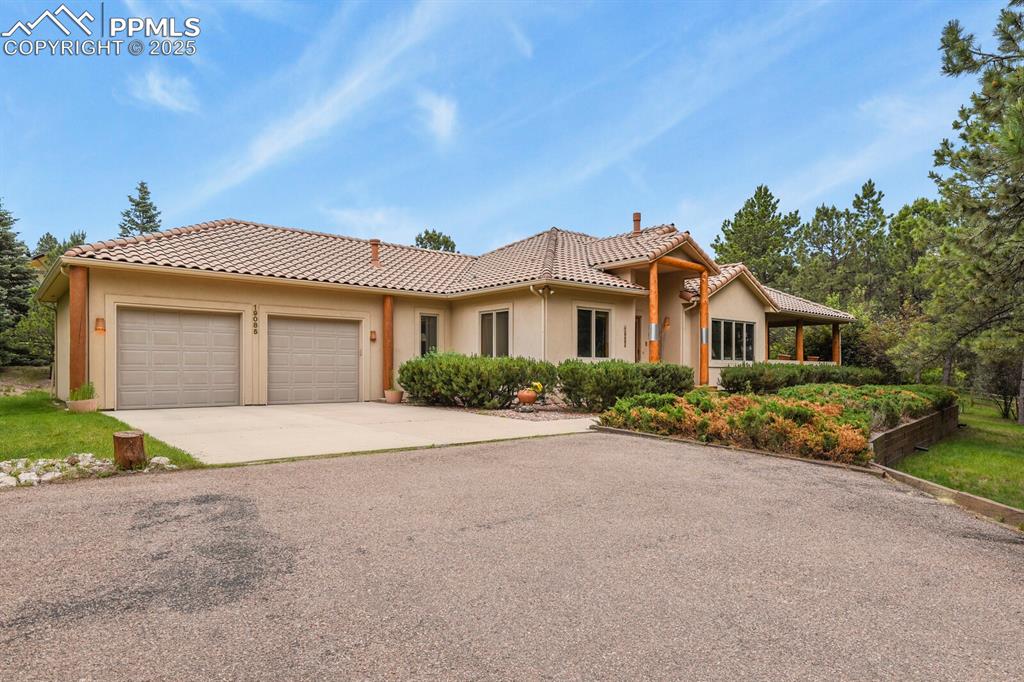Caption: Ranch-style home featuring stucco siding, driveway, a garage, and a tile roof