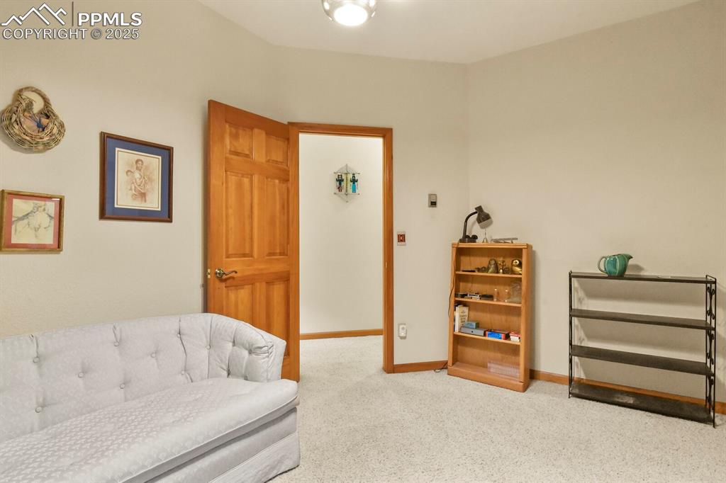 Image 17 of 48: Living area with carpet floors and baseboards