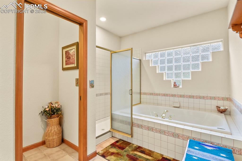 Image 21 of 48: Bathroom with a bath, a shower stall, tile patterned floors, and recessed l