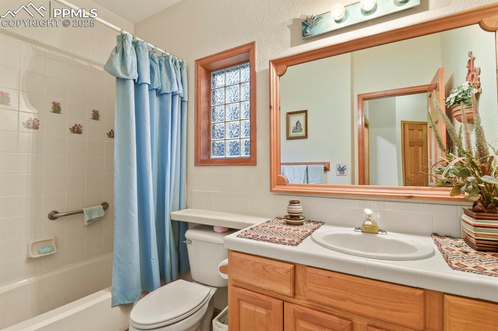 Image 23 of 48: Full bathroom featuring shower / tub combo, vanity, and backsplash