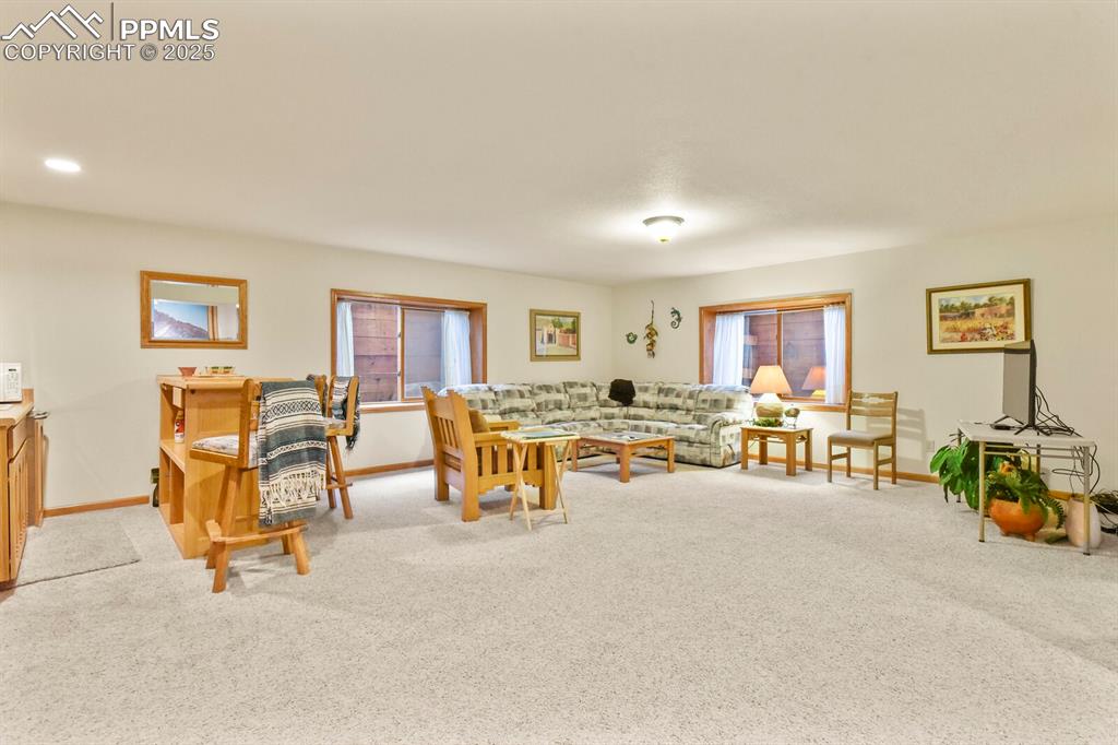 Image 26 of 48: Living room featuring light colored carpet and baseboards