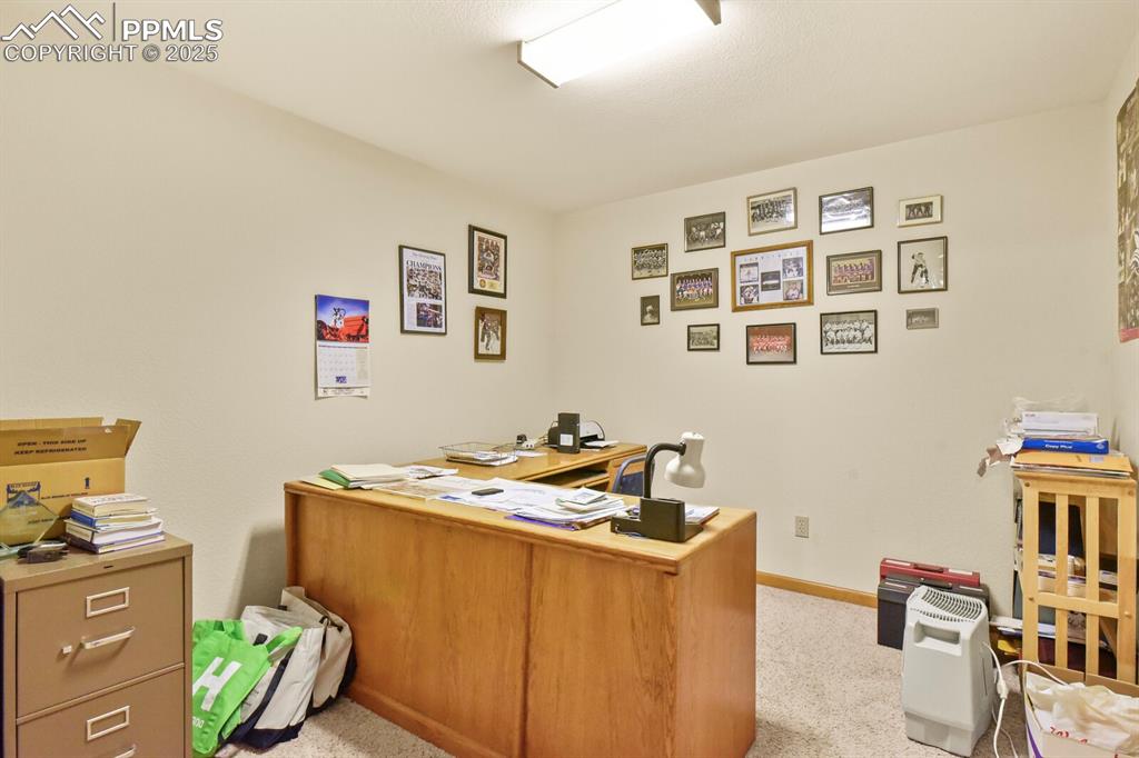 Image 32 of 48: Home office with light colored carpet and baseboards