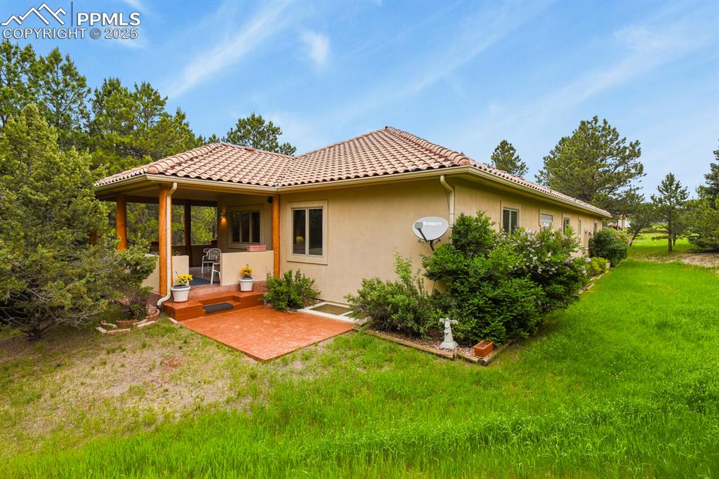 Image 37 of 48: Back of property featuring stucco siding, a lawn, and a patio