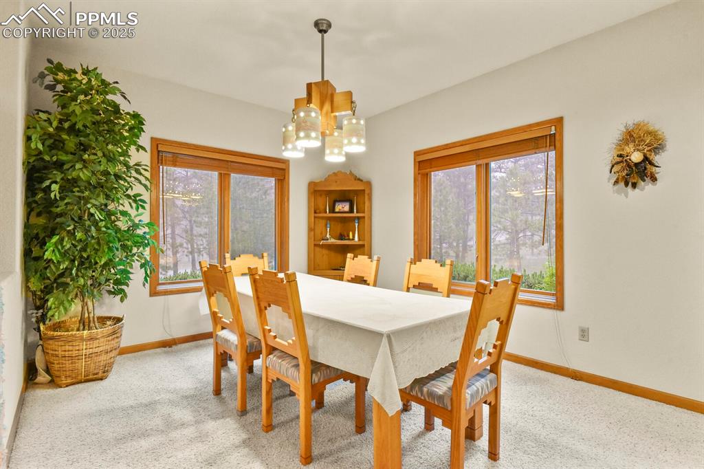 Image 4 of 48: Dining room featuring a chandelier and light colored carpet