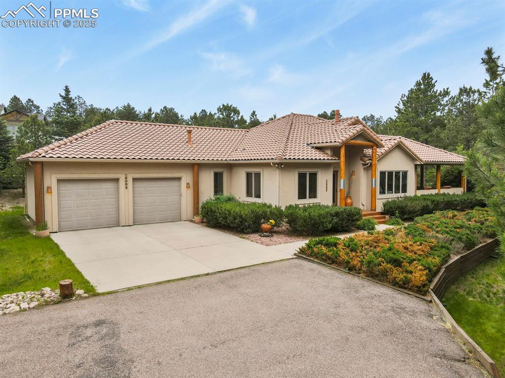 Image 40 of 48: View of front of home featuring driveway, stucco siding, an attached garage