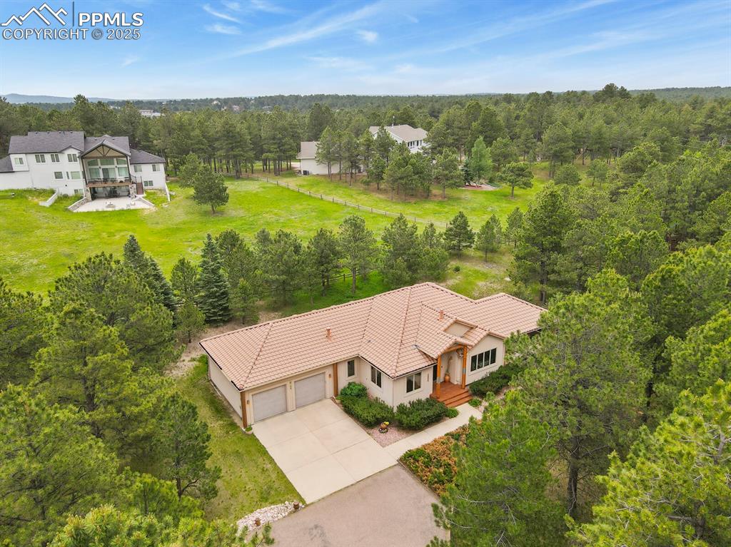 Image 41 of 48: View from above of property featuring a tree filled landscape