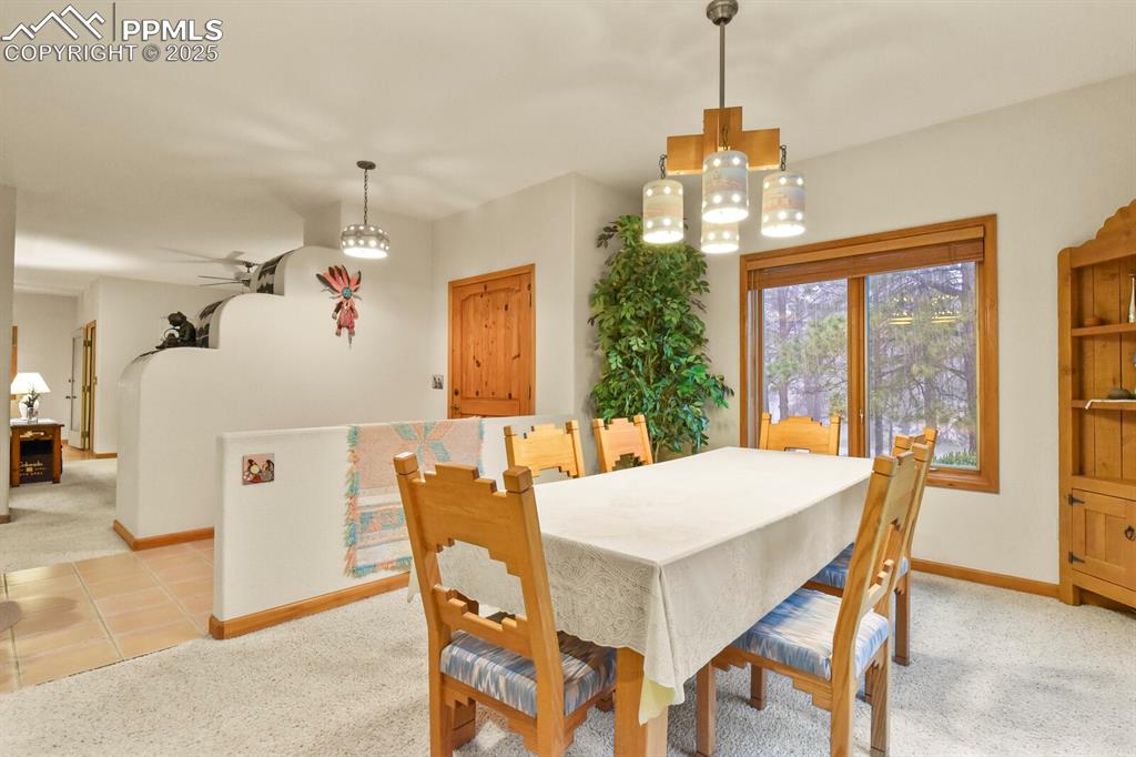 Image 5 of 48: Dining room with light carpet, a chandelier, and light tile patterned floor