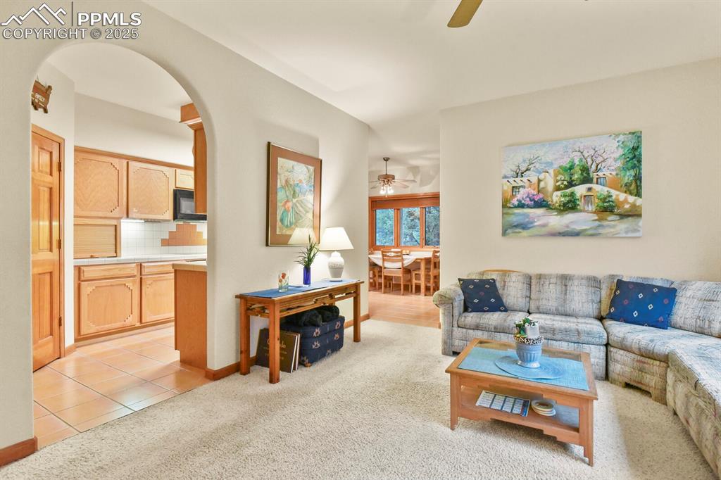 Image 8 of 48: Living area featuring light carpet, ceiling fan, and light tile patterned f