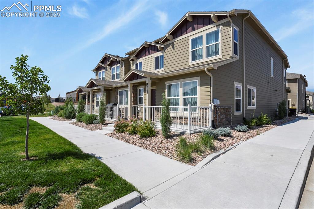 Image 2 of 27: Craftsman house featuring board and batten siding, covered porch, a front y