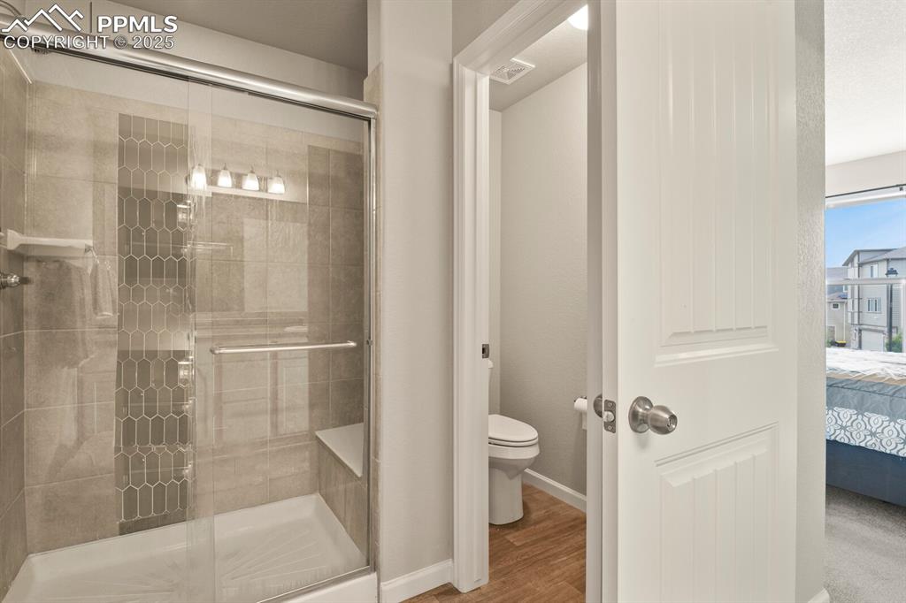 Image 20 of 27: Full bathroom featuring ensuite bath, a shower stall, and wood finished flo