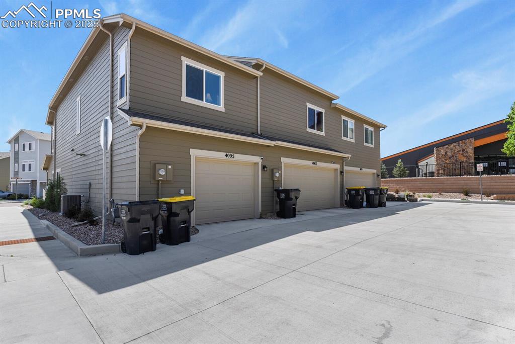 Image 22 of 27: Rear view of house featuring a garage and driveway