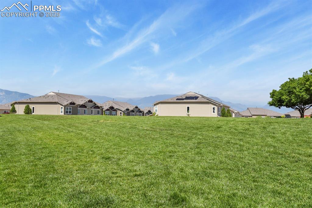 Image 25 of 27: View of grassy yard with a residential view and a mountain view
