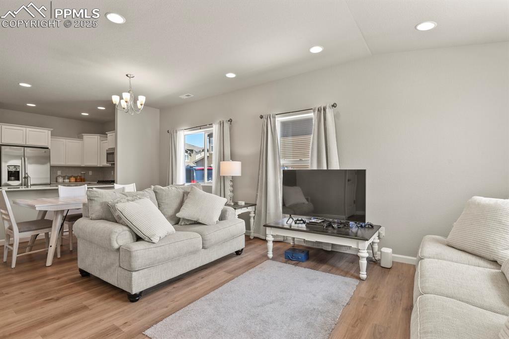 Image 4 of 27: Living area featuring a chandelier, light wood-style floors, and recessed l
