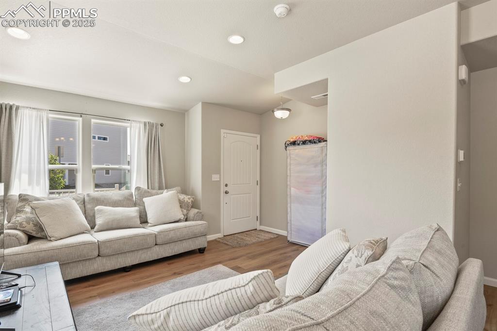 Image 5 of 27: Living room featuring wood finished floors and recessed lighting