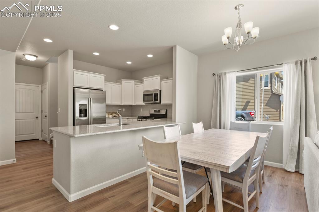 Image 6 of 27: Dining area featuring a chandelier, light wood-type flooring, and recessed 