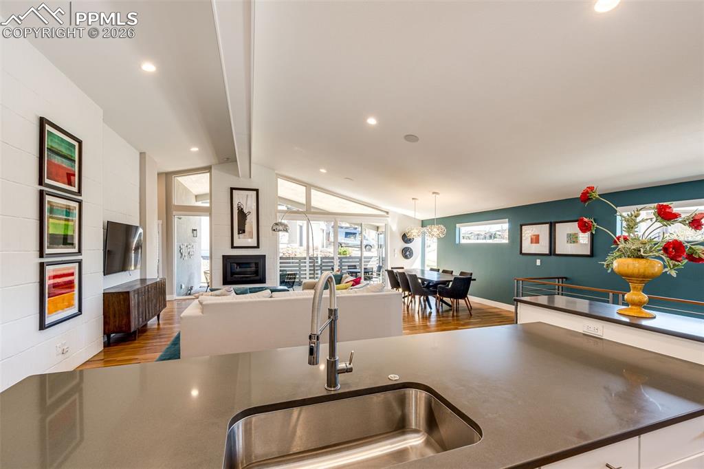 Image 13 of 47: View from the kitchen out to Great room with 12 foot high wall and gas fire