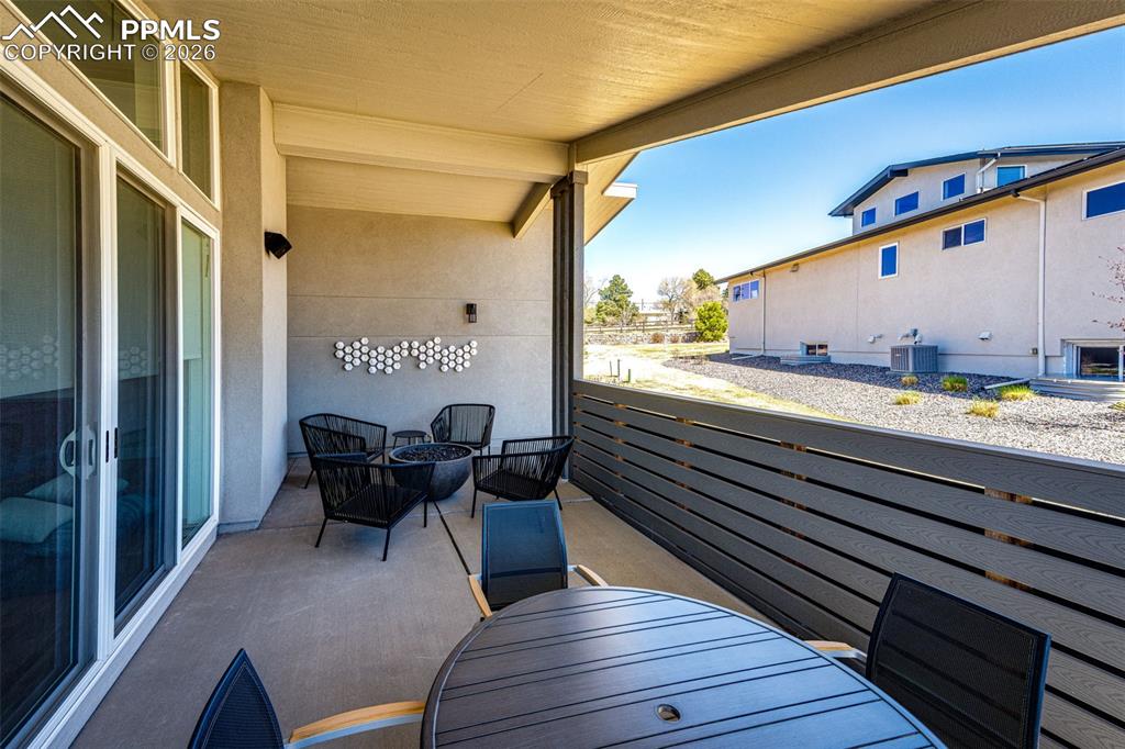 Image 33 of 46: Covered patio with wind break wall