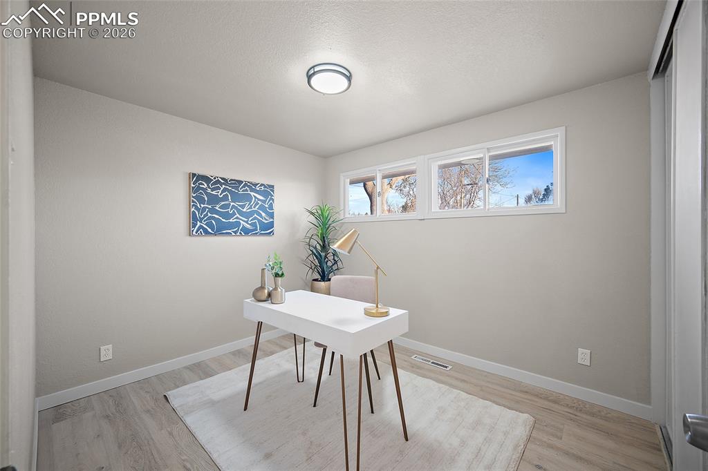 Image 12 of 29: Home office featuring baseboards and light wood-style floors
