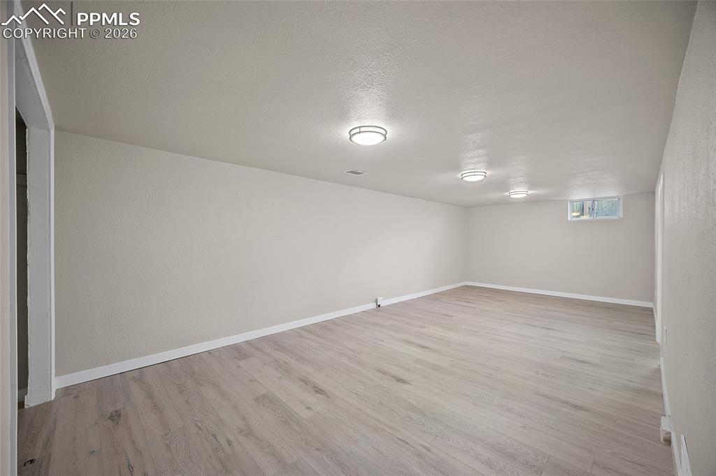 Image 16 of 29: Below grade area featuring a textured ceiling, light wood-style flooring, a