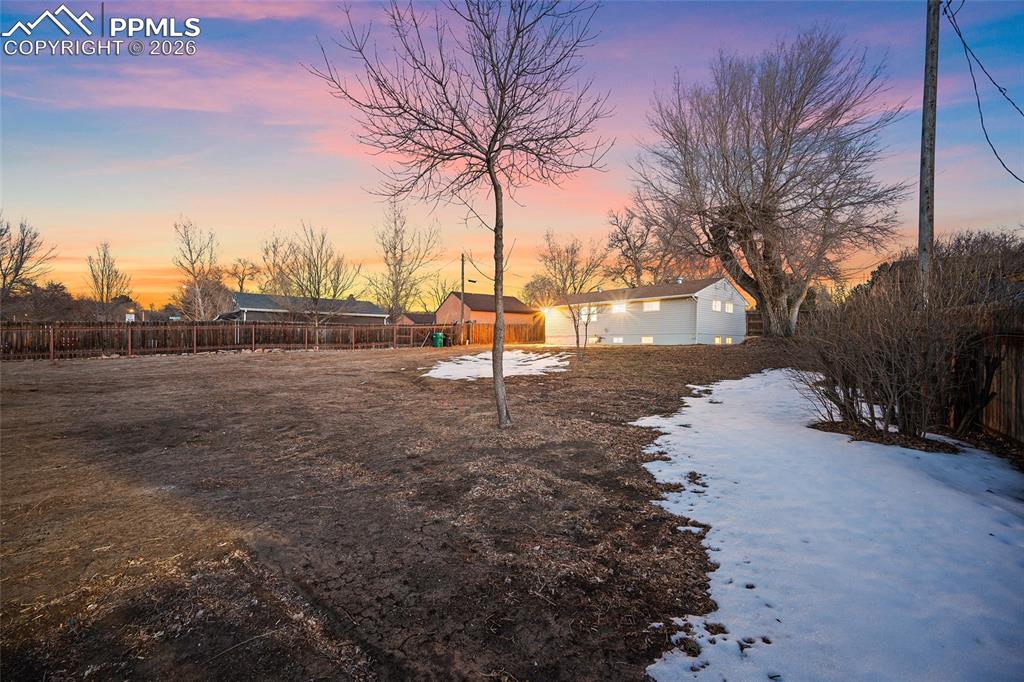 Image 22 of 29: Yard layered in snow featuring a fenced backyard and an outdoor structure