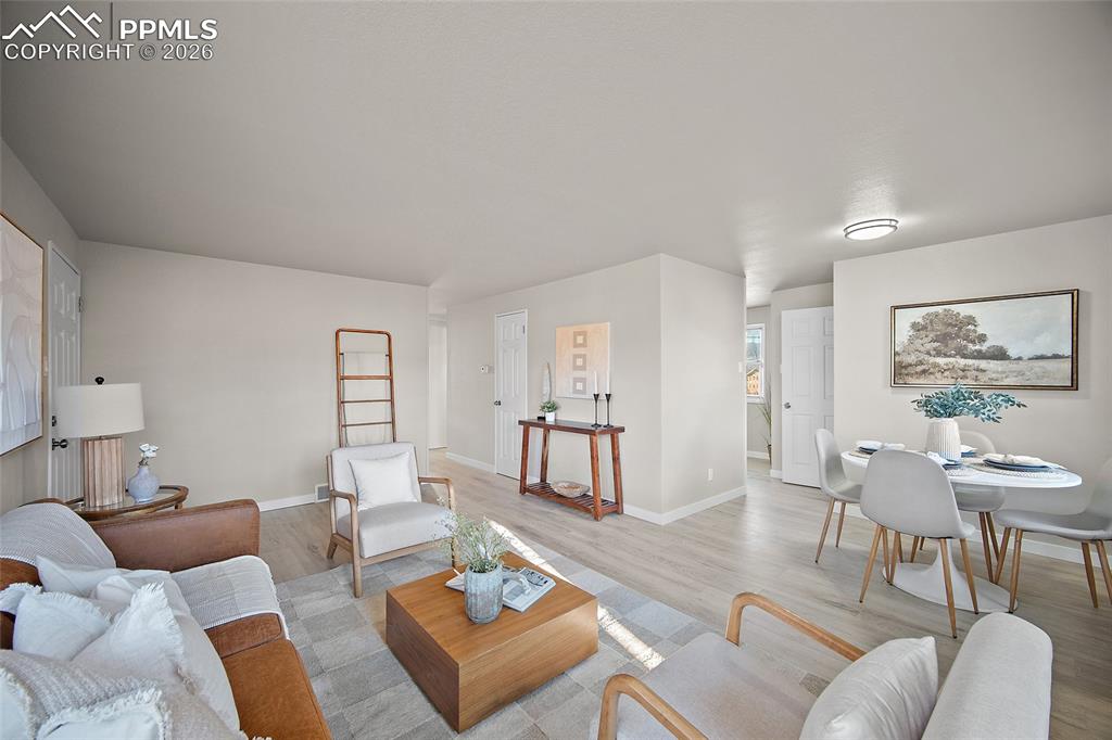Image 3 of 29: Living area with wood finished floors and baseboards