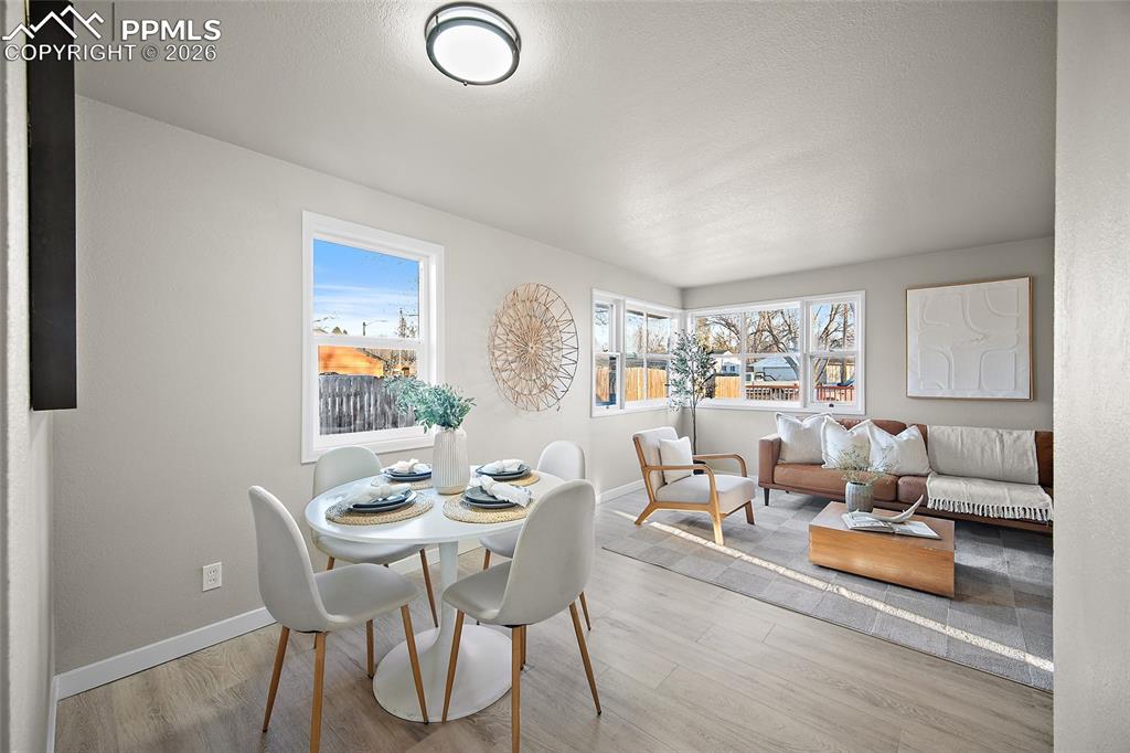 Image 5 of 29: Dining area with light wood-style floors and a textured ceiling