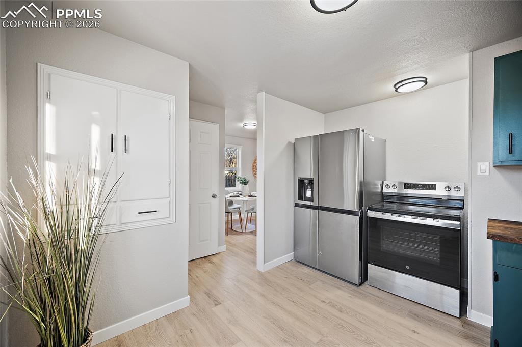 Image 9 of 29: Kitchen featuring stainless steel appliances and light wood finished floors